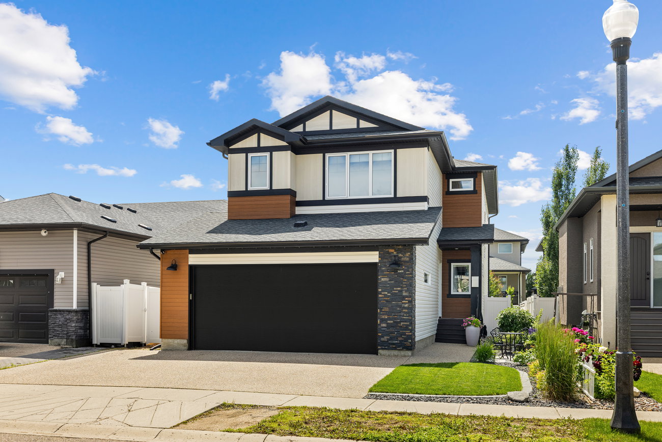 Two-storey home exterior with stone pillars and a covered entry