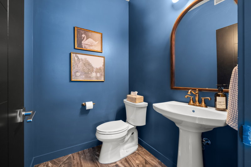 Powder room with a floating vanity and round mirror