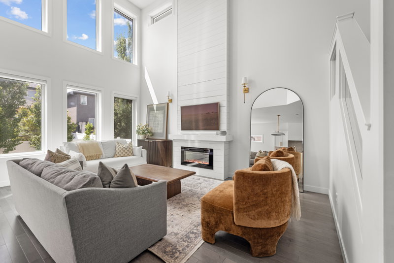 Living room with a tiled fireplace wall and large windows