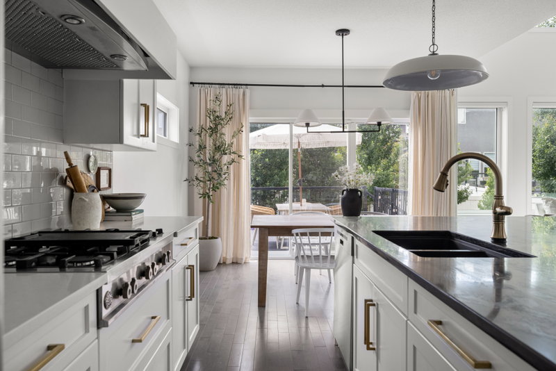 Kitchen sink and counter run beneath pendant lighting