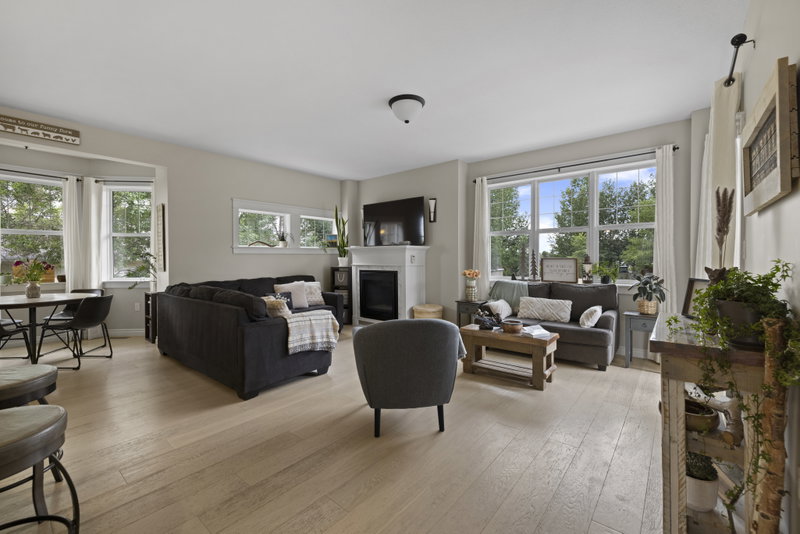 Living room with fireplace, wall-mounted television and large windows