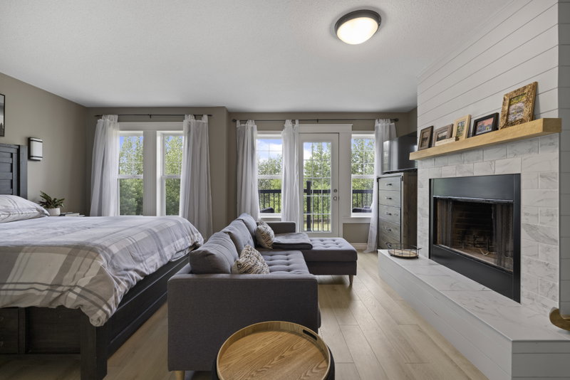 Primary bedroom sitting area with a fireplace and dresser