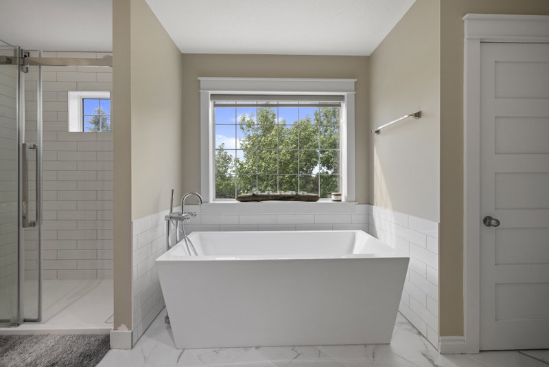 Ensuite with a freestanding tub beneath a garden window