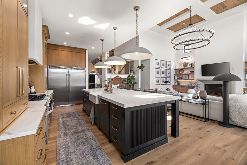 Kitchen island with a view through to the living room and chandelier beyond