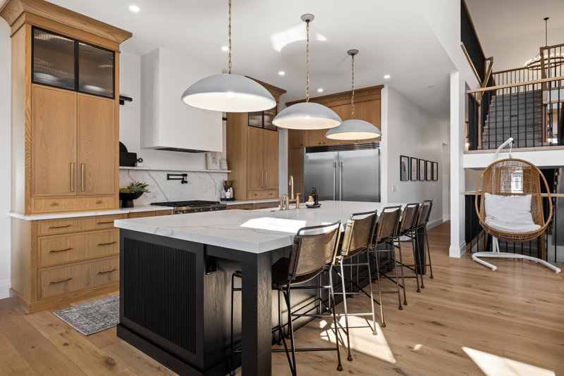 Kitchen with a hanging rattan chair and staircase in the background