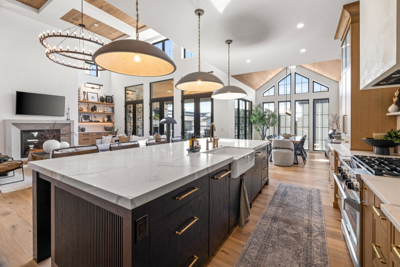 Kitchen with a stone fireplace and vaulted, peaked windows beyond