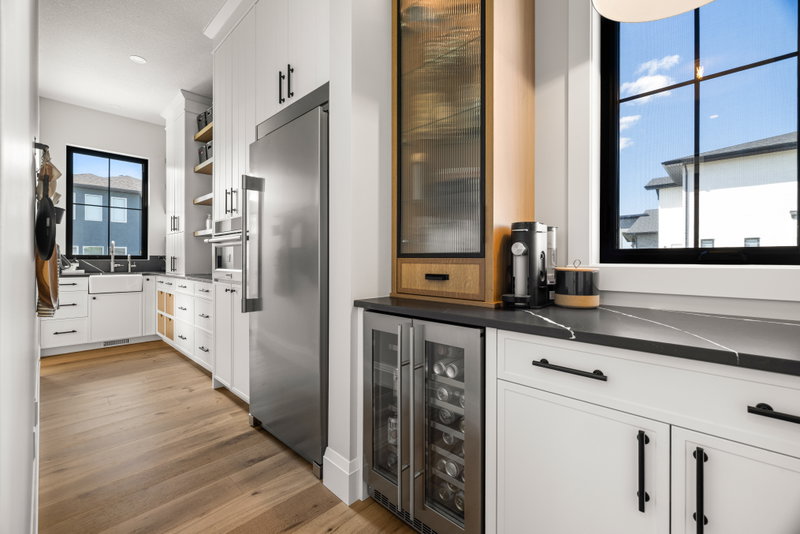 Butler's pantry with beverage fridges and open shelving