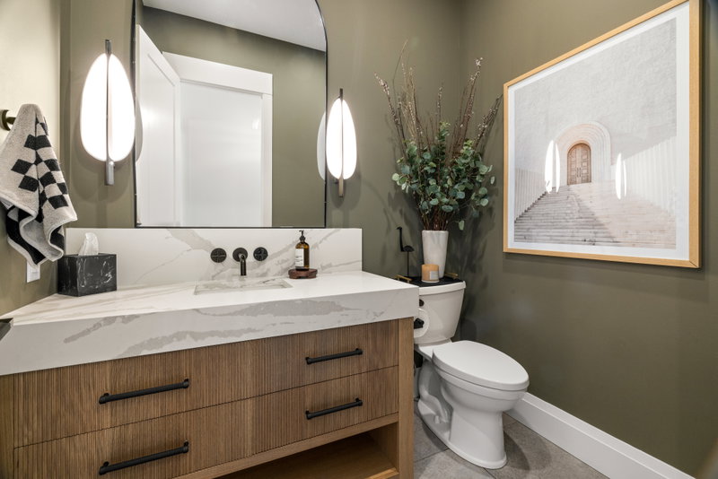 Main floor bathroom with marble-look counter and framed mirror