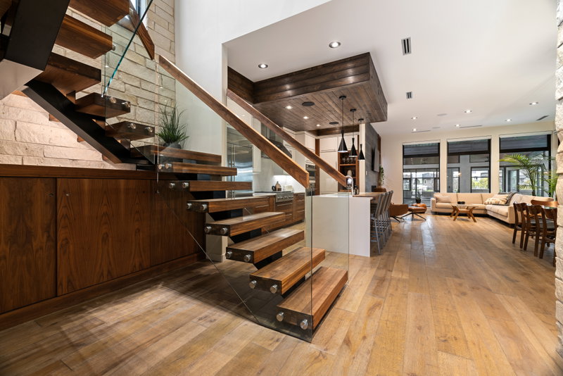 Open staircase with glass railing and walnut treads
