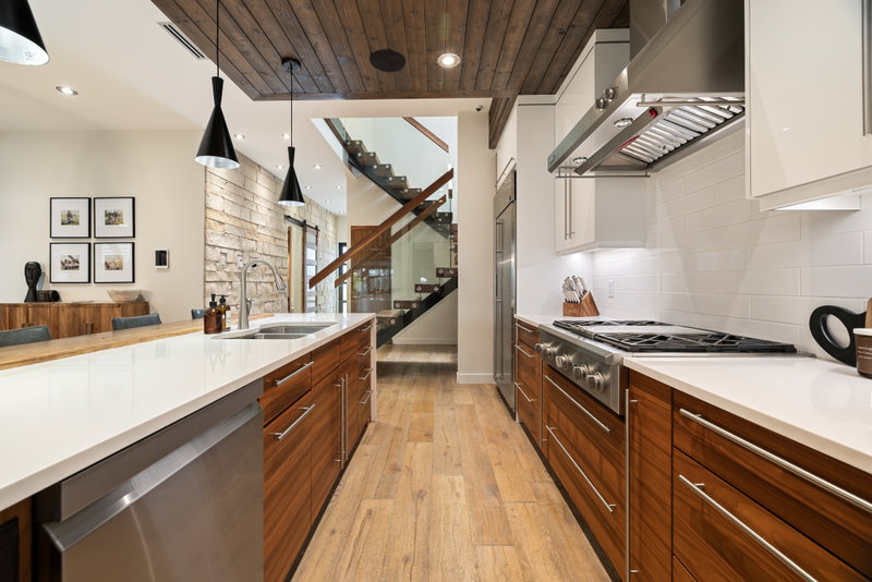 Kitchen with built-in wall ovens and a walnut pantry wall