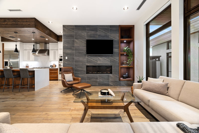 Hearth room with a stone-tiled fireplace wall and walnut shelving