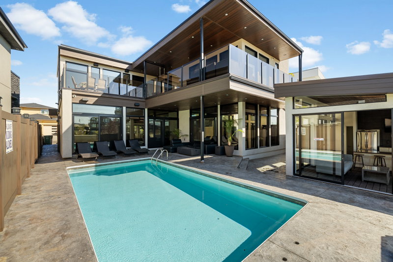 Backyard pool with lounge chairs and a covered outdoor kitchen