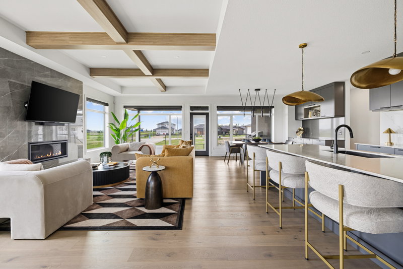 Great room with a stone fireplace wall and kitchen island beyond