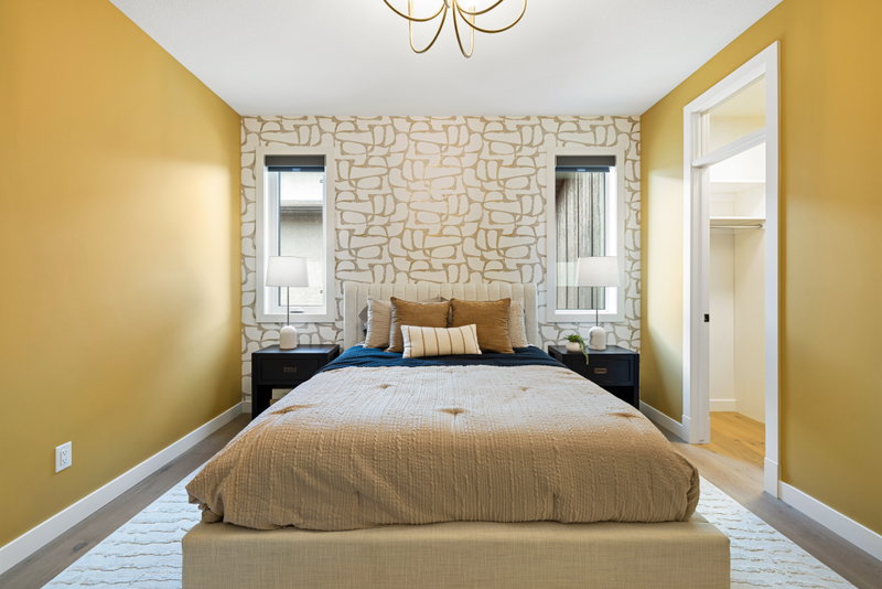 Bedroom with mustard accent wall and upholstered headboard