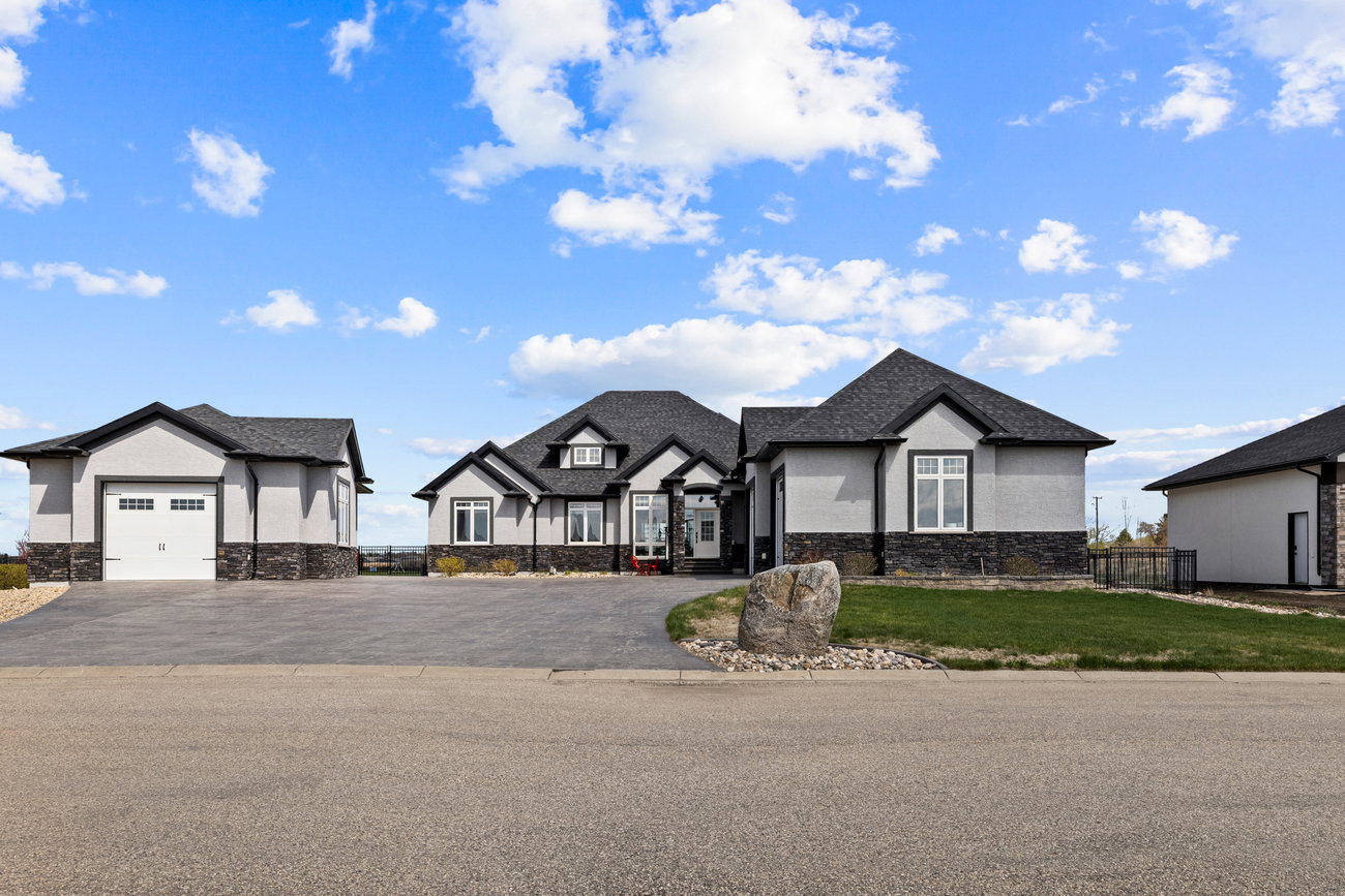 Stone-and-stucco bungalow with a triple garage and circular drive