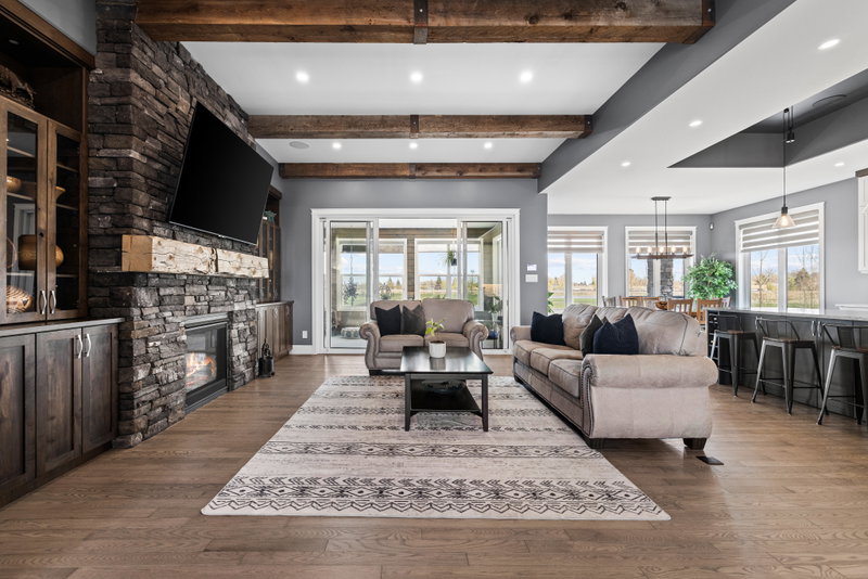 Great room with a stacked-stone fireplace and reclaimed beam ceiling