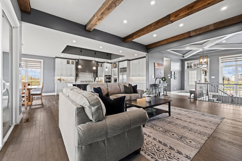 Living room open to the kitchen with a coffered dining ceiling beyond