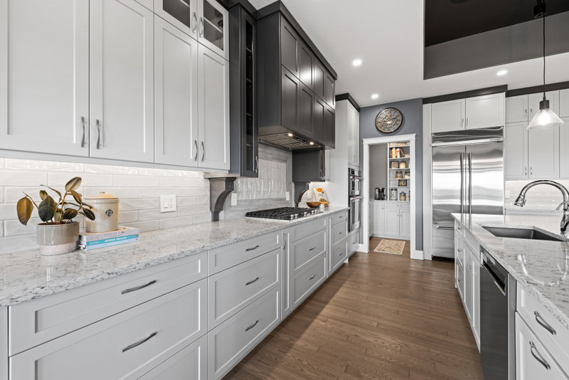 Kitchen with grey cabinetry, walk-in pantry and stainless appliances