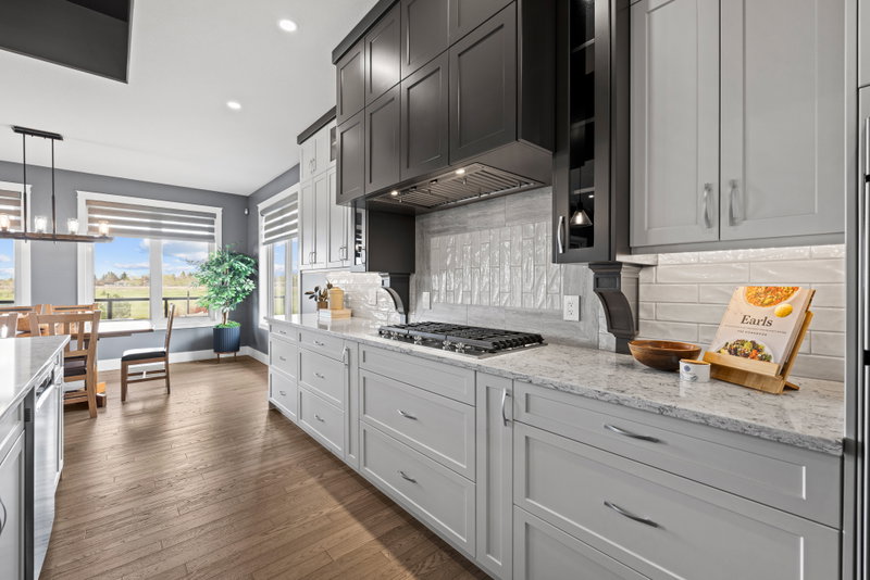 Kitchen range wall with tile backsplash and dark upper cabinets