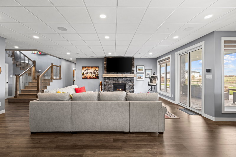 Finished basement family room with a stone fireplace and walkout
