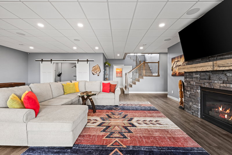 Basement recreation area with staircase and patio doors