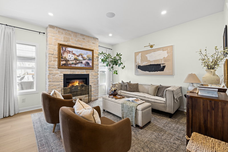 Living room seating area with abstract art and a wood-panelled staircase beyond