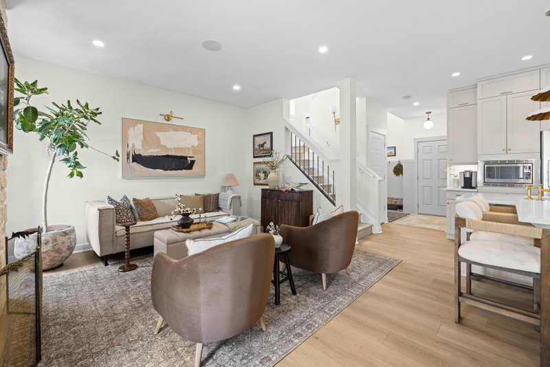 Open living and dining area with a starburst chandelier and gallery-wall mirror
