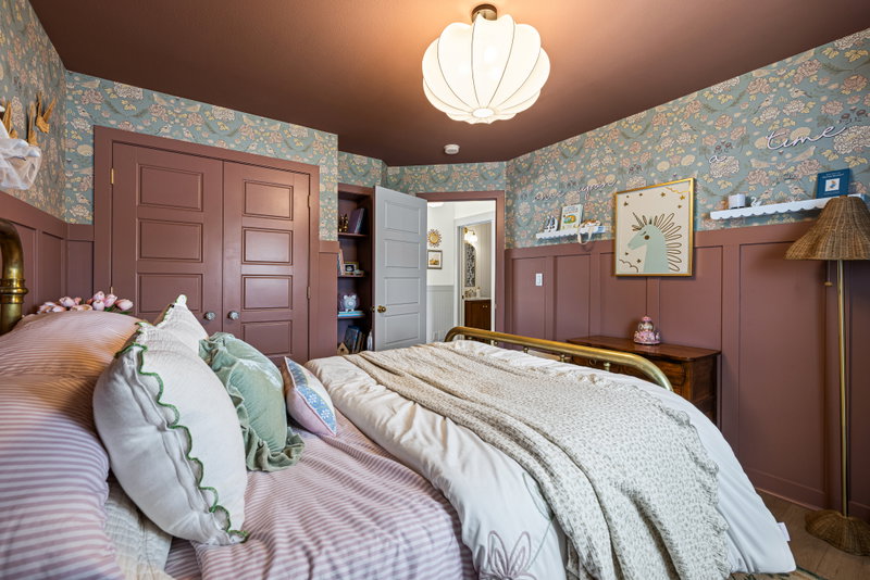 Kids' bedroom with floral wallpaper and a unicorn print
