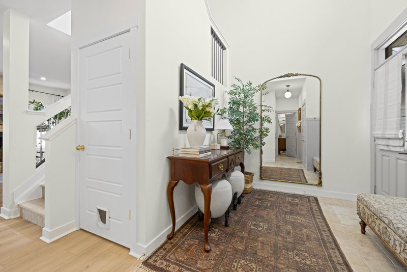 Entry hall with an arched mirror and console table beneath a vaulted ceiling