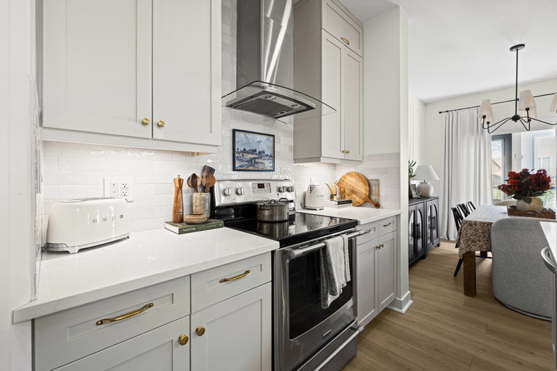 Range and hood with wood cutting boards and a view to the dining room