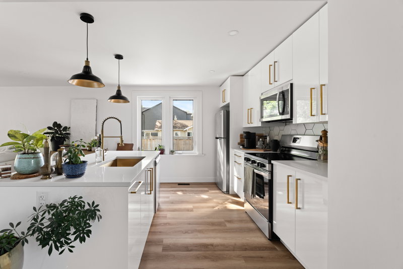Kitchen with white cabinetry and a view down the hallway