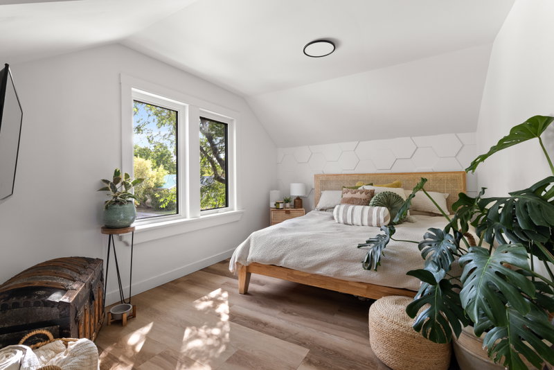 Primary bedroom with a rattan headboard and hexagon-tile feature wall