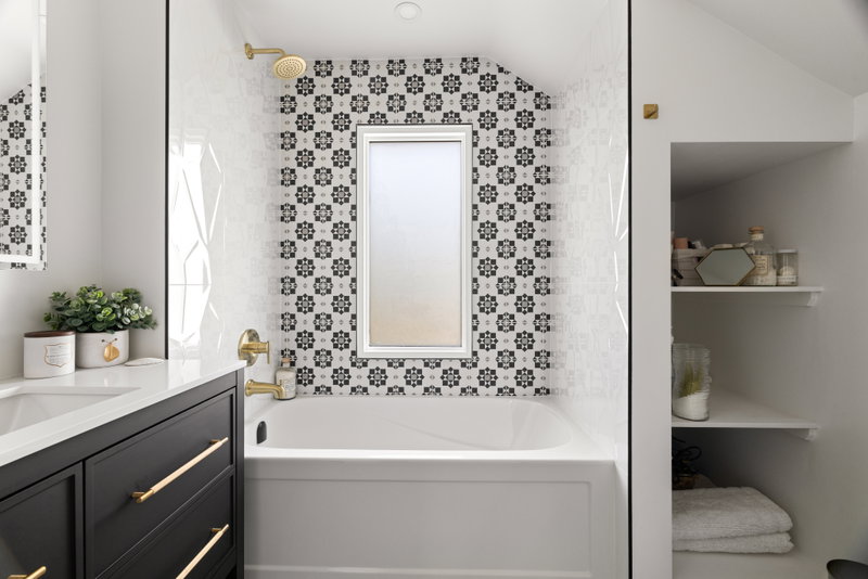Bathroom with a soaker tub, patterned tile and built-in shelving