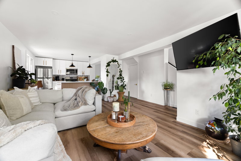 Living room with a round wood table, sectional and wall-mounted television