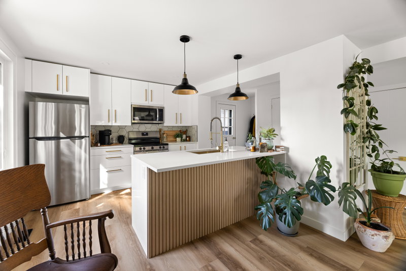 White kitchen with a fluted wood island and brass hardware
