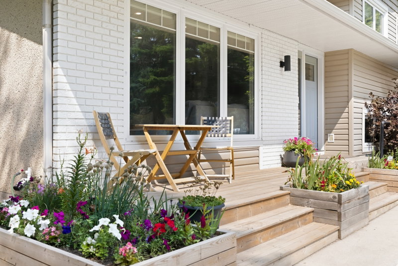 Covered front porch with seating among planted flower boxes