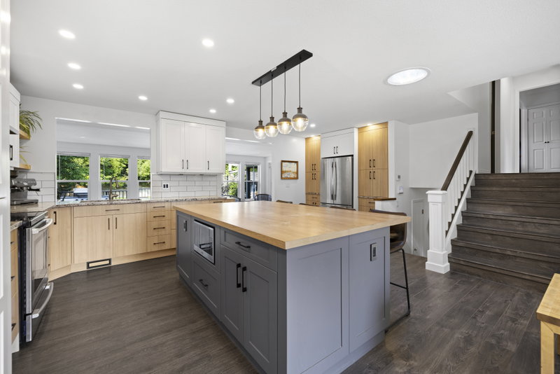 Kitchen with wood cabinetry and a staircase to the upper level