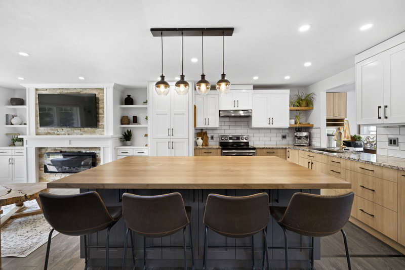 Kitchen open to a stone fireplace with built-in shelving