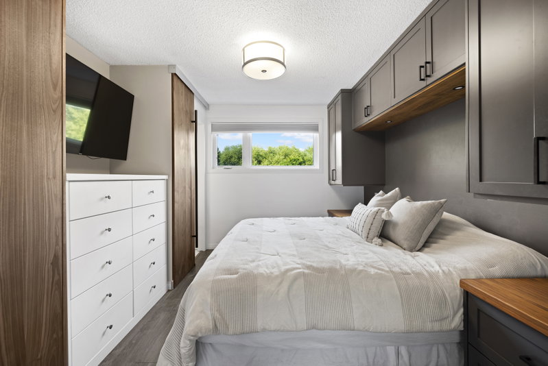 Primary bedroom with built-in cabinetry and wall-mounted television