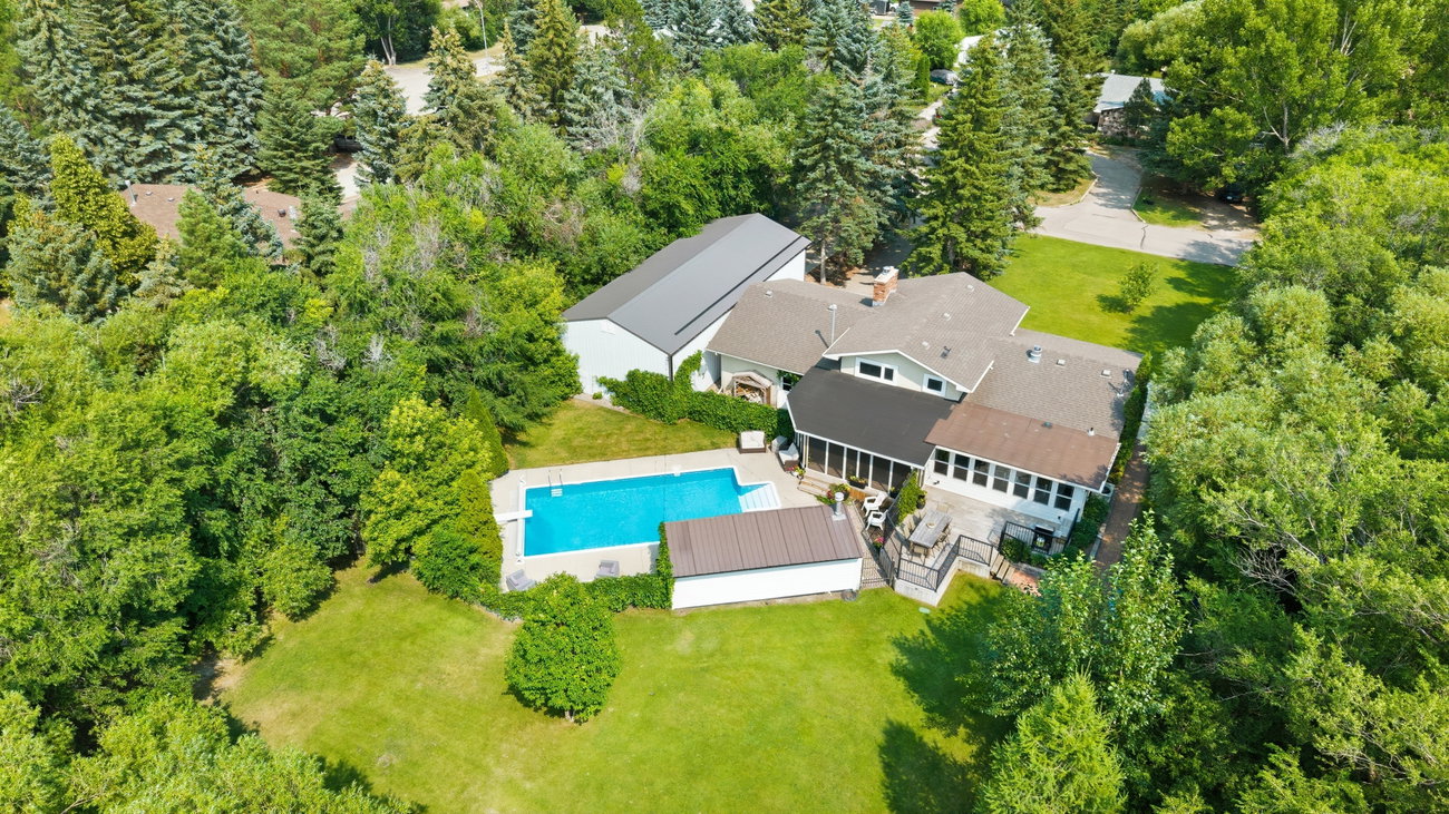 Aerial photograph of the home and pool nestled among mature trees