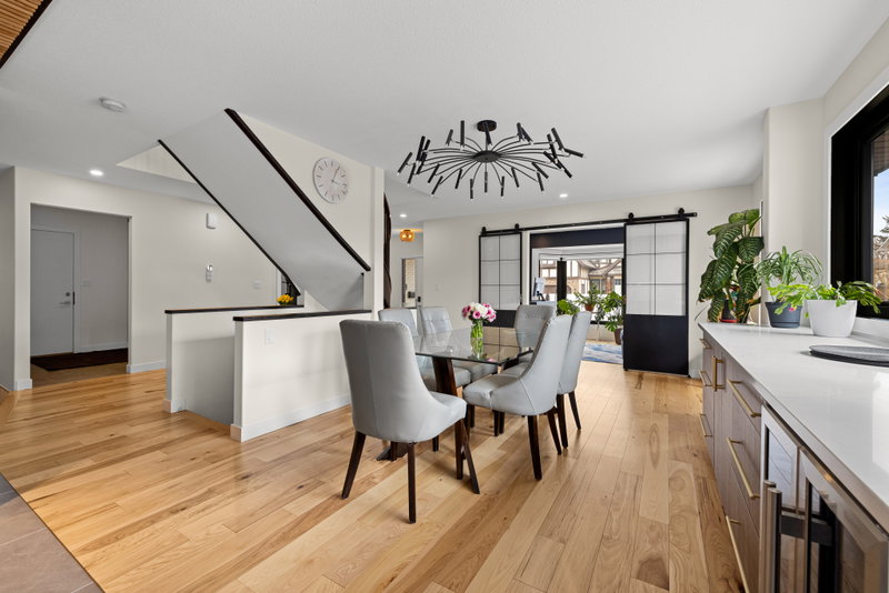 Open dining area with sculptural chandelier and sliding barn doors