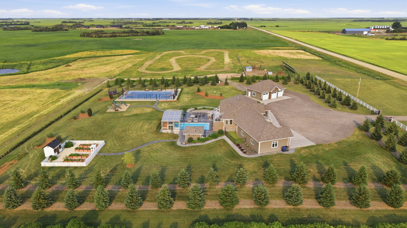 Aerial photograph of the property and pool from the side, overlooking the surrounding acreage