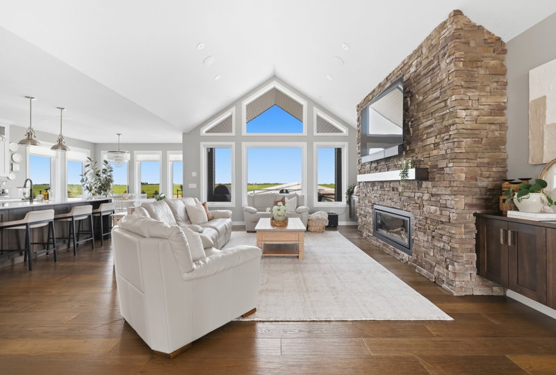 Living room and kitchen viewed from the front entry, beneath a vaulted ceiling