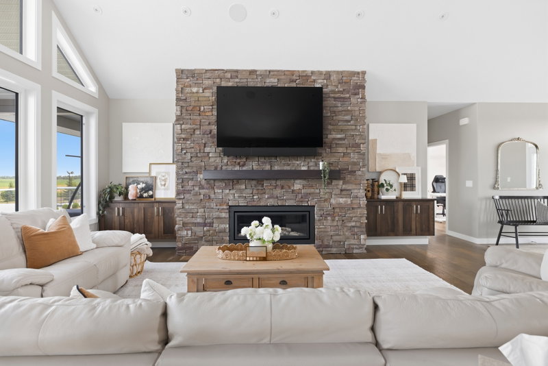 Living room fireplace flanked by a gallery wall, open to the front hallway