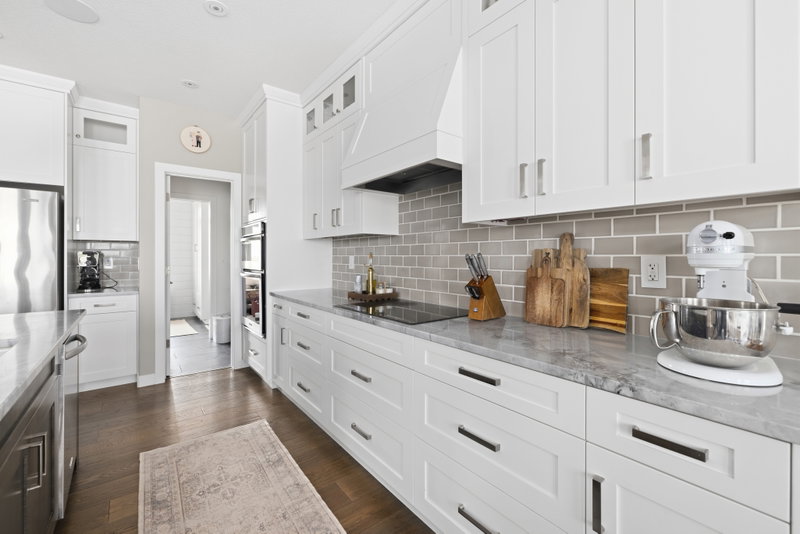 Kitchen counter with cutting boards and a stand mixer, beneath a tile backsplash