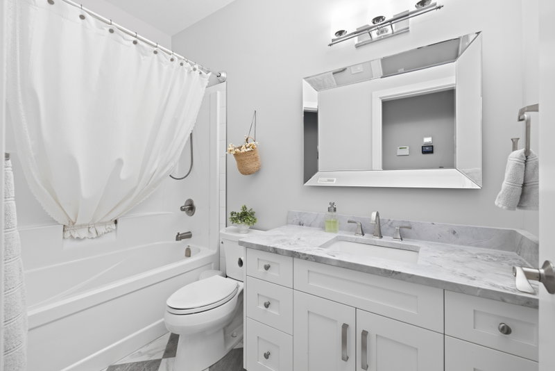 Bathroom with a marble-look vanity and a tub-and-shower combo