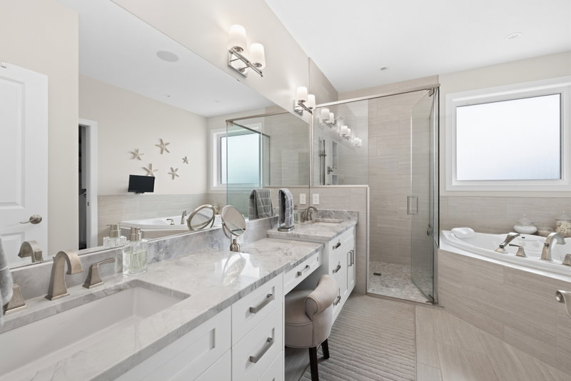 Primary ensuite with a soaker tub, glass walk-in shower and double vanity