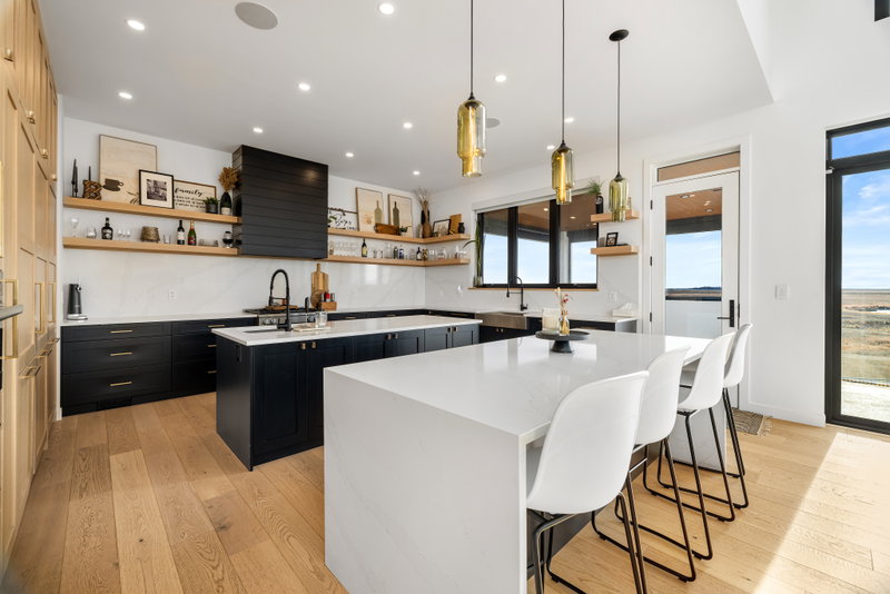Kitchen with white cabinetry, island seating and pendant lighting